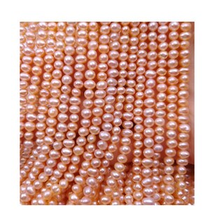 May include: A strand of pale pink freshwater pearls. The pearls are oval shaped and have a smooth, lustrous finish.