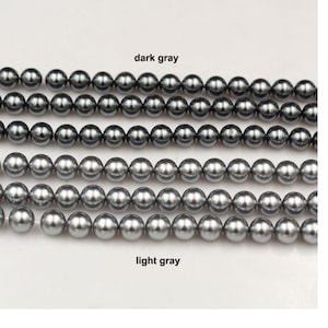 以下が含まれることがあります： グレーの真珠ビーズが2列並んだクローズアップ。上の列は「ダークグレー」、下の列は「ライトグレー」とラベル付けされています。
