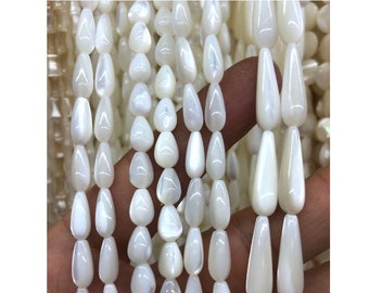 May include: A strand of white teardrop-shaped beads made from mother of pearl.