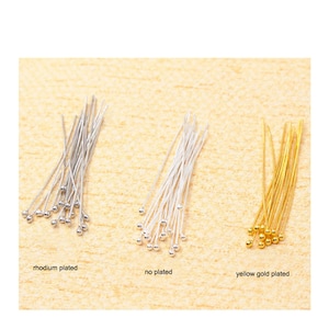 May include: Three sets of head pins in rhodium plated, no plated, and yellow gold plated finishes. Each pin has a small ball at the end. The text in the image reads "rhodium plated", "no plated", and "yellow gold plated".