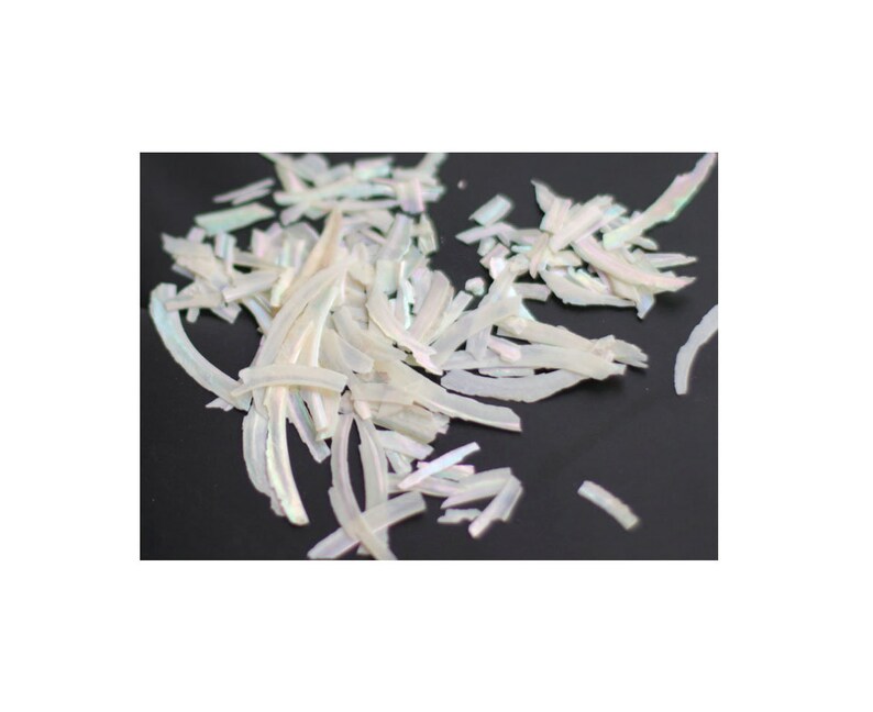 May include: A pile of iridescent white shell flakes, perfect for adding a touch of shimmer to crafts and nail art.
