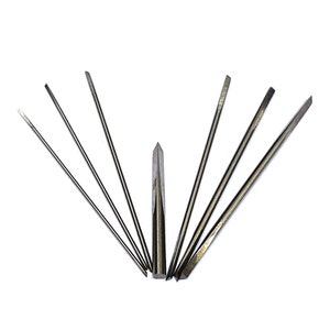 May include: A set of seven silver metal tools with pointed tips. The tools are arranged in a fan shape on a white background.