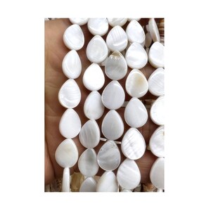 May include: A strand of white teardrop-shaped shell beads. The beads have a pearlescent finish and are strung on a white cord.