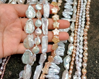 May include: A variety of pearl necklaces in different shapes and colors. The pearls range from white to peach and gold, with some shaped like stars. The necklaces are displayed against a dark background, showcasing their luster and unique forms.