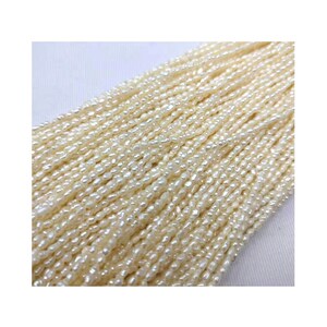 May include: A strand of off-white freshwater pearls, each pearl is a slightly irregular oval shape. The pearls are strung on a thin thread and are ready to be used for jewelry making.