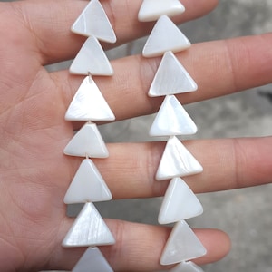 May include: Two strands of white triangle-shaped beads made from mother of pearl.