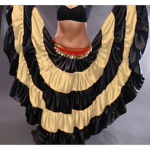 May include: A black and gold satin dance skirt with multiple layers and ruffles. The skirt is designed for belly dancing or other performance styles.