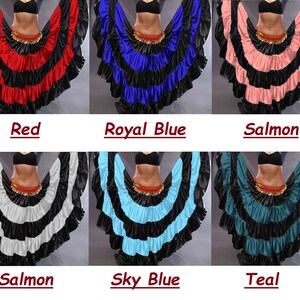 May include: Six different colors of a layered, ruffled skirt. The skirt is black with a layer of red, royal blue, salmon, white, sky blue, and teal fabric. The skirt is worn by a person with a black top and a gold belt.