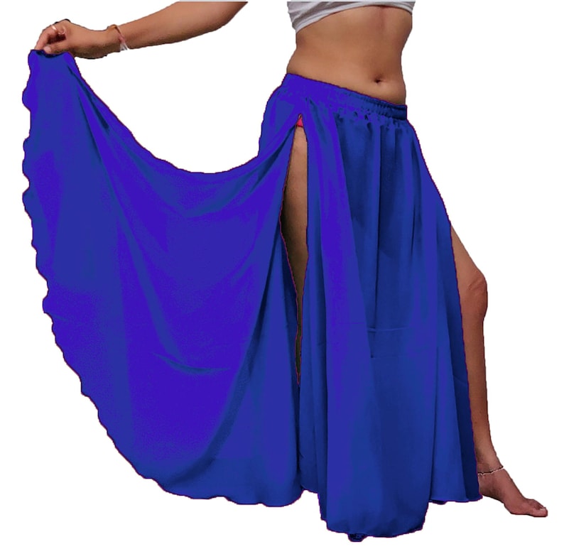 Puede incluir: Una falda larga de color azul real vibrante con una cintura alta el&aacute;stica y dos aberturas laterales dram&aacute;ticas que se extienden desde el dobladillo hasta la cadera, creando una silueta fluida y voluminosa con un borde festoneado.