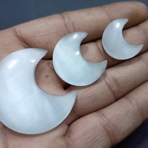 Puede incluir: Tres piedras de selenita blancas en forma de media luna de diferentes tamaños.