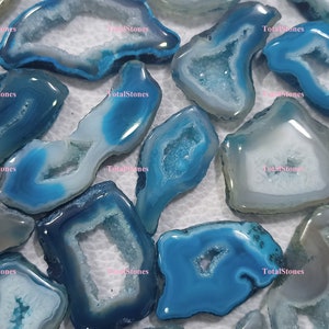 May include: A collection of blue and white agate slices with natural crystal formations. The agate slices are irregularly shaped and have a translucent appearance.