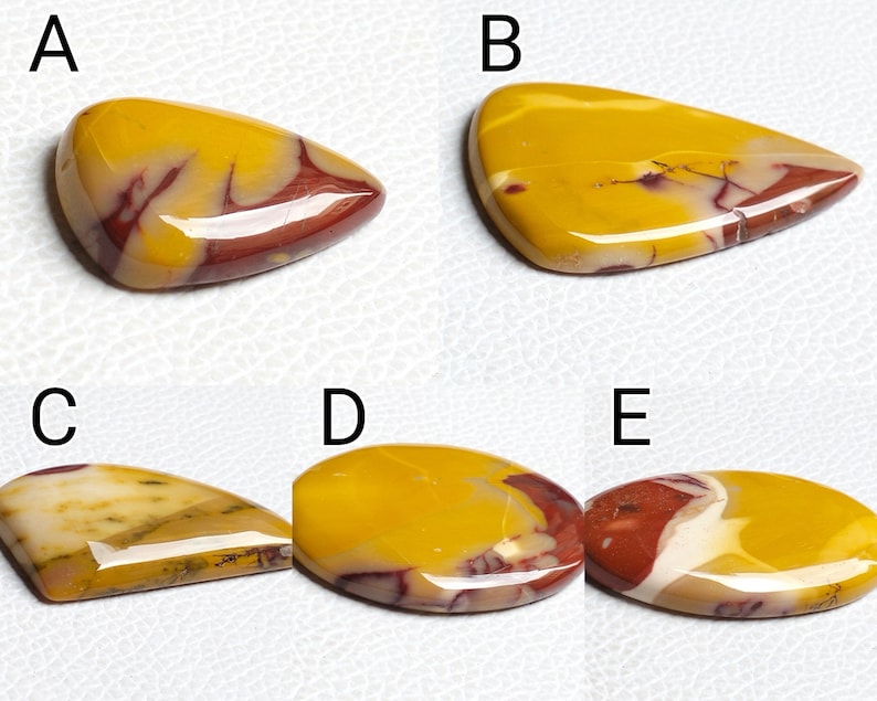 Op de afbeelding: Vijf gepolijste, kleurrijke, natuurlijke stenen cabochons in verschillende vormen en maten. De stenen zijn een mix van geel, rood en wit.