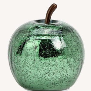 Puede incluir: Una figura decorativa de manzana con un acabado verde esmeralda craquelado. La manzana tiene un tallo marrón oscuro y una forma redondeada. Adecuado para la decoración del hogar.