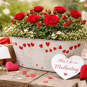 Könnte beinhalten: Ein Blumenarrangement mit roten Rosen und weißen Blüten in einem weißen ovalen Pflanzgefäß, verziert mit roten Herzen. Ein Geschenk mit roter Schleife und eine herzförmige Karte sind ebenfalls vorhanden.