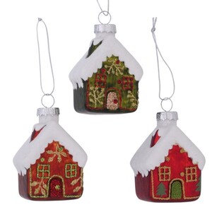 Könnte beinhalten: Drei Weihnachtsbaumschmuck aus Glas in Form von Häusern. Jedes Haus hat ein weißes, schneebedecktes Dach und einen farbenfrohen Körper. Die Häuser sind rot, grün und rot. Die Häuser haben dekorative Details wie Fenster und Türen.