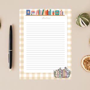 Puede incluir: Bloc de notas rayado con un borde de patrón de cuadros vichy beige claro. El bloc de notas presenta un diseño decorativo de estantería en la parte superior y una pila de libros con acentos florales en la parte inferior. La palabra "Notes" está escrita en cursiva.