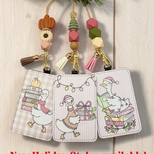 May include: Three rectangular ID badge holders featuring cartoon goose illustrations, each attached to a gold-tone clasp with a colorful beaded lanyard and a small tassel. The text New Holiday Styles available is printed at the bottom.