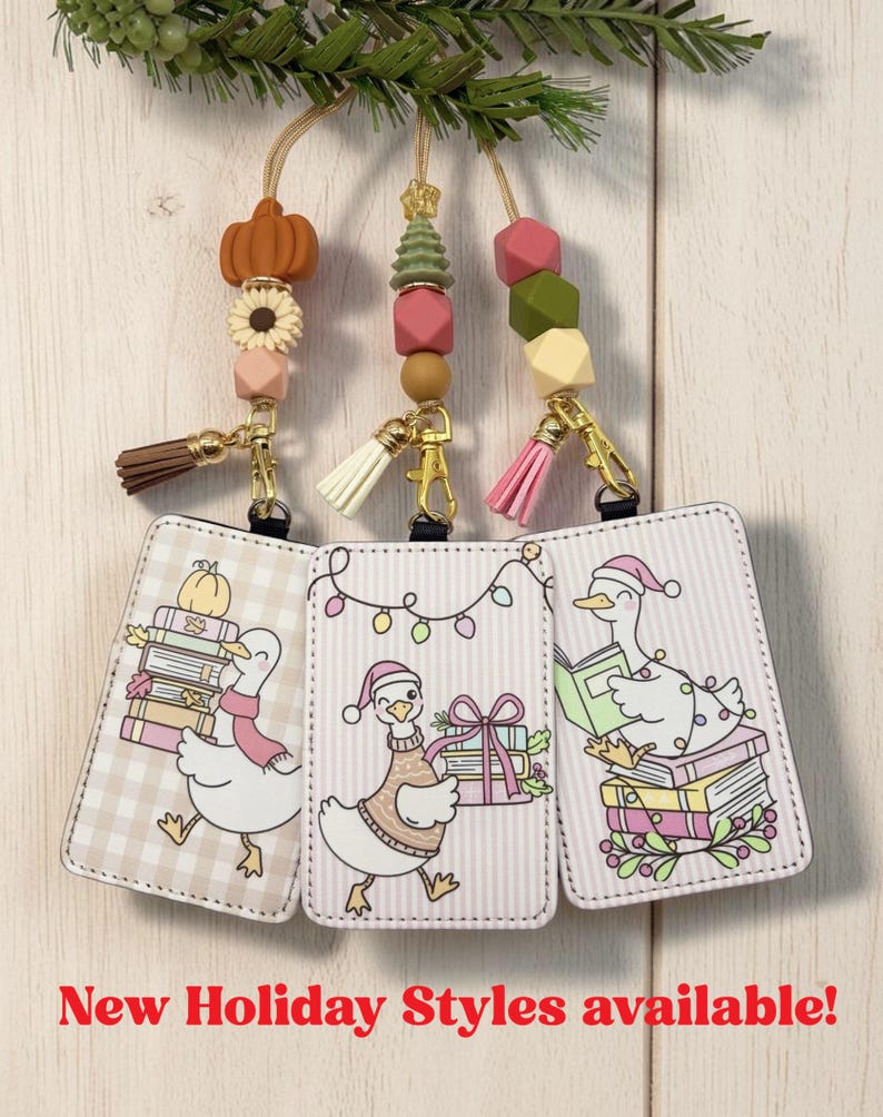 May include: Three rectangular ID badge holders featuring cartoon goose illustrations, each attached to a gold-tone clasp with a colorful beaded lanyard and a small tassel. The text New Holiday Styles available is printed at the bottom.