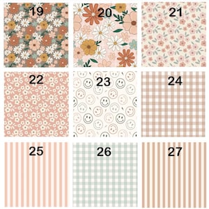May include: A grid of nine fabric patterns labeled 19 through 27. Designs include floral prints with daisies and wildflowers in orange, white, and pink, a smiley face pattern, a beige gingham check, and vertical stripes in pink and light green.