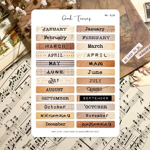 Puede incluir: Un conjunto de 12 pegatinas de calendario mensual de estilo vintage con un esquema de color marr&oacute;n y beige. Las pegatinas presentan los meses del a&ntilde;o en una fuente de m&aacute;quina de escribir. El texto "Good Times" y "No. M_02" est&aacute; impreso en la parte superior de la hoja. Las pegatinas est&aacute;n dise&ntilde;adas para ser utilizadas en planificadores, diarios y otras manualidades de papel.