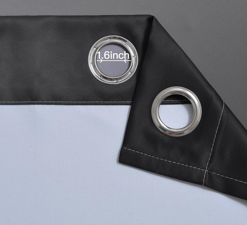 Puede incluir: Primer plano de un panel de cortina negro con una arandela plateada. La abertura de la arandela tiene 4,1 cm de di&aacute;metro. La cortina tiene un forro blanco y un fondo gris.