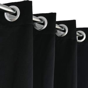 Puede incluir: Primer plano de cortinas negras con ojales plateados y una barra de cortina plateada. La tela es de color negro liso, y los ojales est&aacute;n espaciados uniformemente a lo largo del borde superior. Las cortinas cuelgan en pliegues verticales.