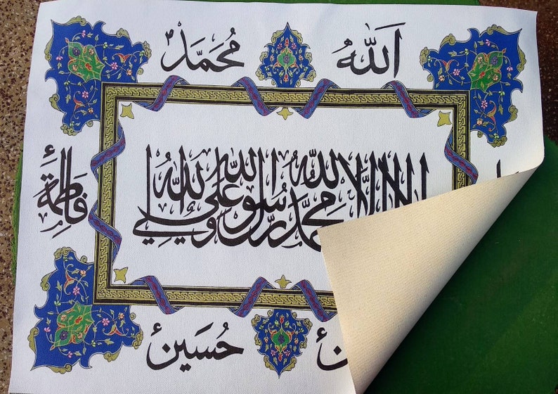 May include: A white canvas with intricate blue and gold calligraphy in Arabic script. The text includes the words "Allah" and "Muhammad". The canvas is framed with a decorative border of blue and gold floral designs.