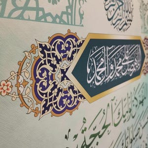 May include: A decorative Islamic art print with intricate gold and blue floral designs. The print features Arabic calligraphy in a green and gold frame.
