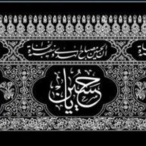 May include: A decorative banner with Arabic calligraphy in green and yellow against a black background. The banner has a silver patterned border and repeated text elements.