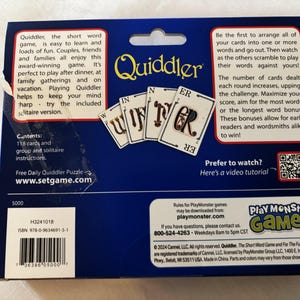 May include: A Quiddler card game box with a blue background. The box features the game's logo and images of cards spelling "WINNER". Text on the box describes the game's rules and contents, including 118 cards and instructions.