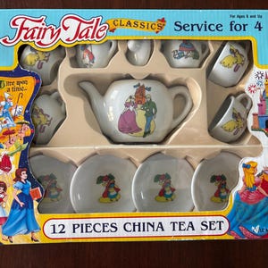 May include: A 12-piece Fairy Tale Classics china tea set for four, featuring a teapot, cups, and saucers. The set is decorated with fairytale characters and scenes, packaged in a colorful box with the text "Fairy Tale Classics".