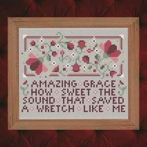 May include: Cross-stitch embroidery in a wooden frame with a floral design and the text "Amazing Grace, How Sweet The Sound That Saved A Wretch Like Me".
