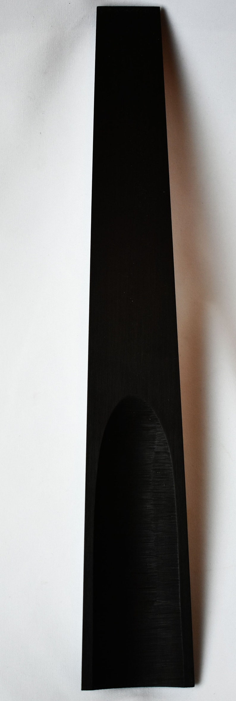 May include: A black wooden serving tray with a curved indentation in the center.