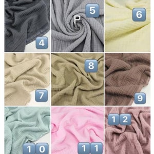 May include: A collection of swirled, textured fabric samples in various colors, including light blue, white, cream, gray, and pink. Each sample is numbered for easy identification. The fabrics appear soft and lightweight.