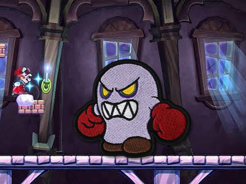 May include: Embroidered patch of an angry cartoon ghost with yellow eyes and red boxing gloves. The ghost is light purple with a black outline. The background shows a video game scene with a character and a spooky castle.