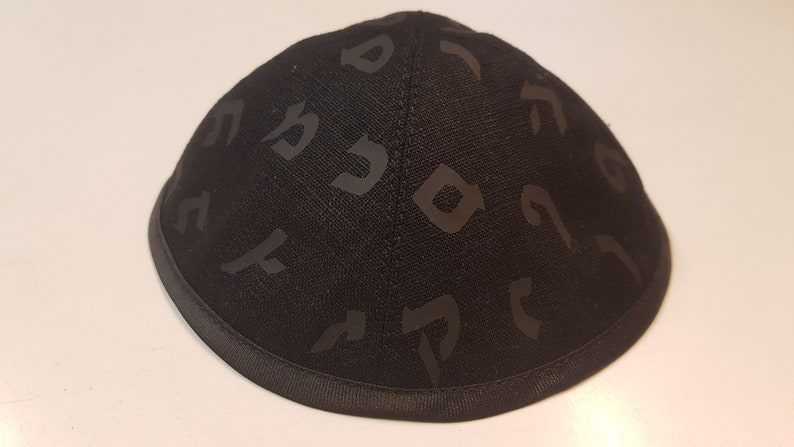 Pu&ograve; includere: Una kippah nera con un motivo ebraico. La kippah &egrave; realizzata in un tessuto morbido e testurizzato.