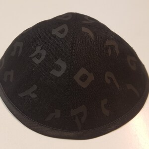 Pu&ograve; includere: Una kippah nera con un motivo ebraico.