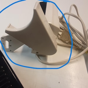 Può includere: Pedale beige per macchina da cucire con base nera e cavo di alimentazione bianco. Il pedale ha un design curvo e una parte superiore nera. Il cavo di alimentazione è bianco e fissato con un laccio giallo.