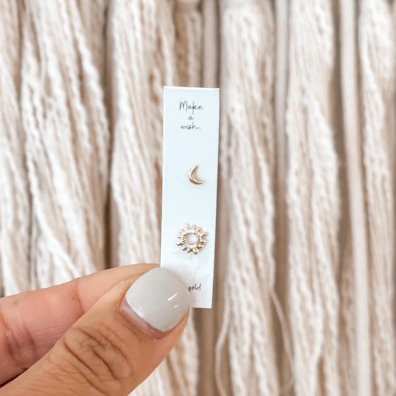 Minimalist moon and sun 10K gold stud earrings displayed on branded card, perfect as a celestial jewelry gift.