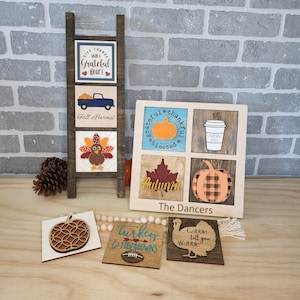 May include: Wooden fall-themed decorations, including a ladder with square panels and a larger square panel with autumn designs. The panels feature pumpkins, leaves, and text like "Give Thanks" and "Fall Harvest."
