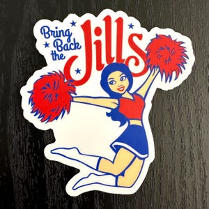May include: A sticker featuring a cartoon cheerleader in a red and blue outfit, holding red pom-poms. The text "Bring Back the Jills" is displayed in blue and red, with star accents. The sticker has a white border.