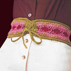 May include: A crocheted belt with a green, pink, and red pattern. The belt is tied in a bow at the front.