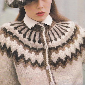Könnte beinhalten: Eine Frau trägt eine beige, braun und weiß gemusterte Strickjacke mit passendem Barett. Die Strickjacke hat einen weißen Kragen und dekorative silberne Knöpfe. Das Barett hat ein Zickzack-Design.