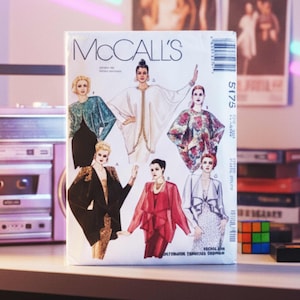 May include: A vintage McCall's sewing pattern featuring illustrations of women's fashion designs. The pattern packet is white with the brand name in large, black letters. The designs include a variety of jackets, dresses, and tops in various colors and patterns.