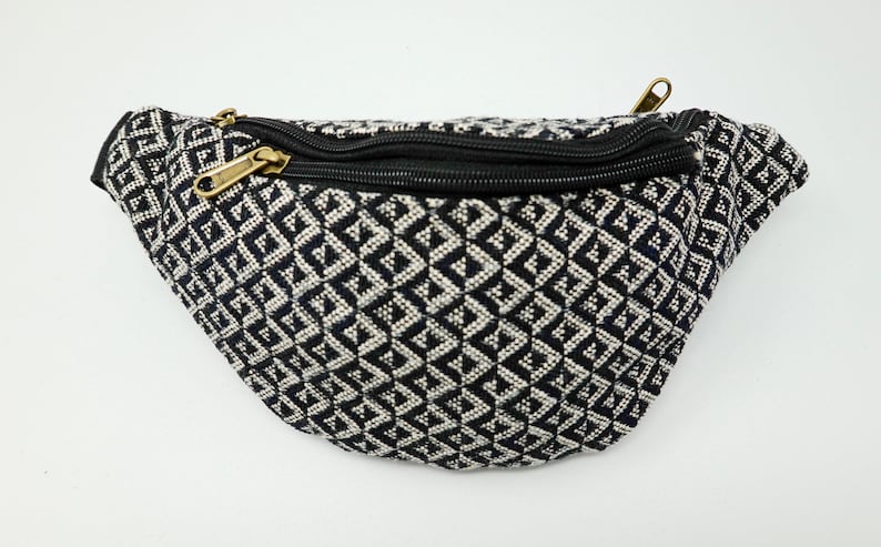 May include: Black and white geometric patterned fanny pack with a black zipper.