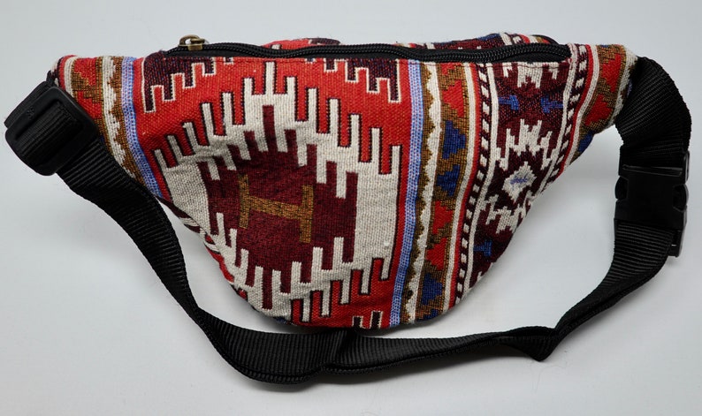 May include: A red, white and blue patterned fanny pack with a black adjustable strap and buckle.