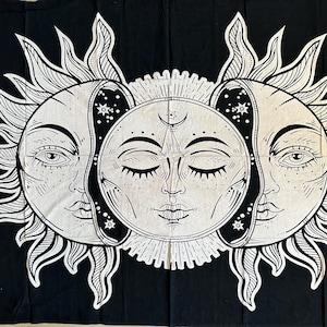 Peut inclure: Tapisserie noire et blanche représentant un soleil et une lune stylisés avec des visages. Le soleil a des rayons et la lune a une forme de croissant.