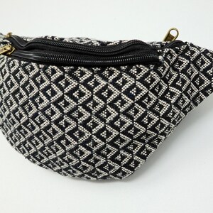 May include: Black and white geometric patterned fanny pack with a black zipper and a gold zipper pull.