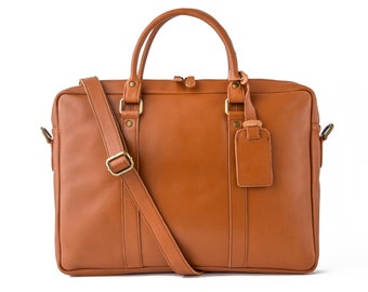 May include: A brown leather briefcase with a shoulder strap and a luggage tag. The briefcase has a zipper closure and a top handle.