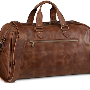 May include: A brown leather duffel bag with a top handle and a shoulder strap. The bag has a zippered pocket on the front and brass hardware.